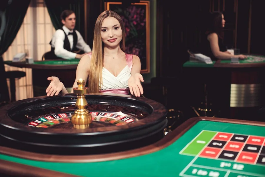 Dealer memandu permainan meja kasino live di depan kamera